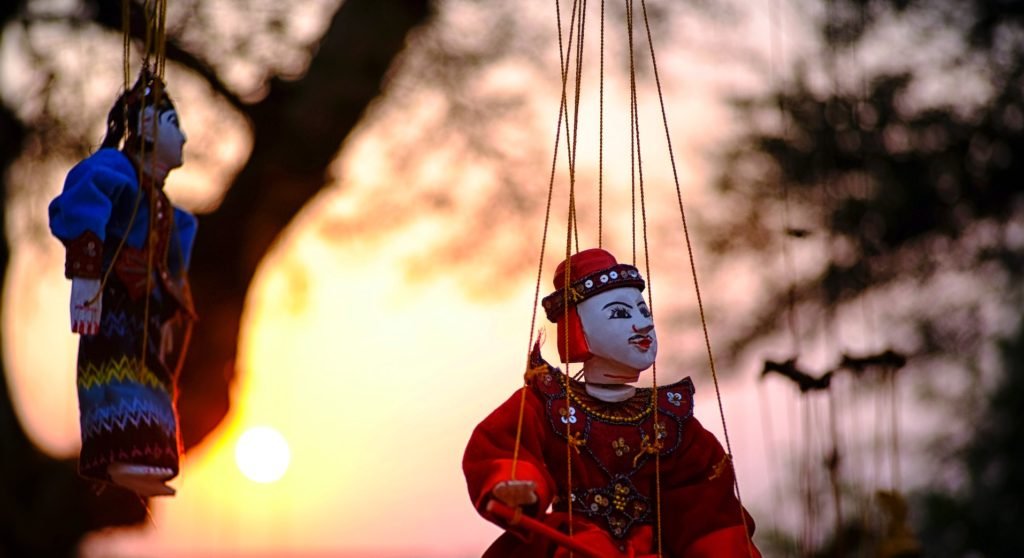 picture of staged hanging puppets (Photo by Min Thein from Pexels)