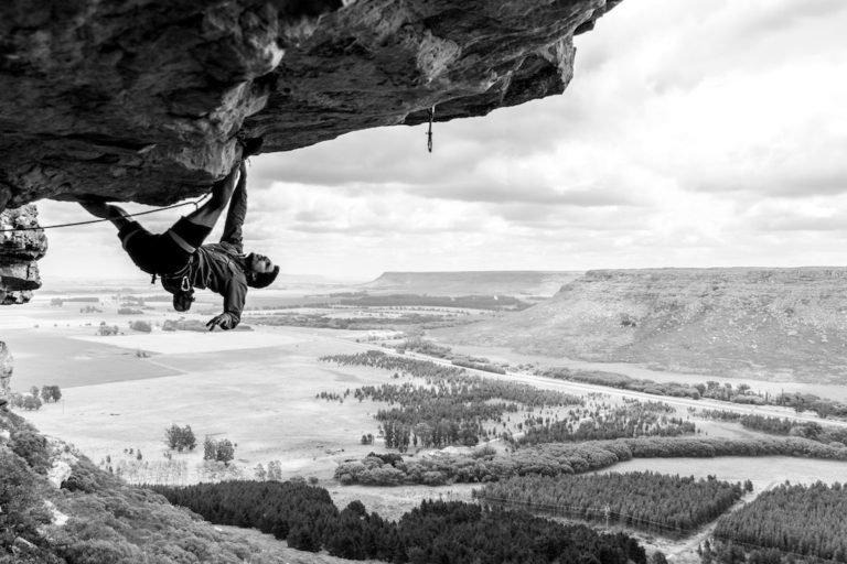man climbing a cliff