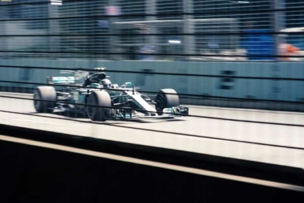 green mercedes f1 car on grey track