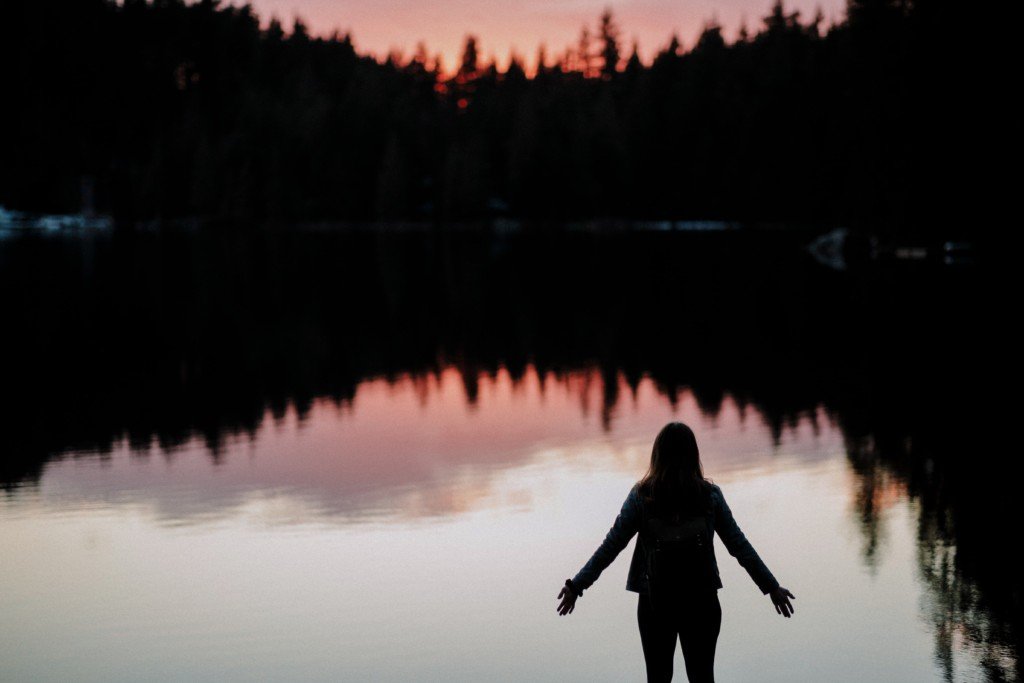 lady with arms opened at a lake