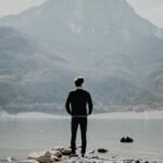 Image of a man looking in the distance across a lake