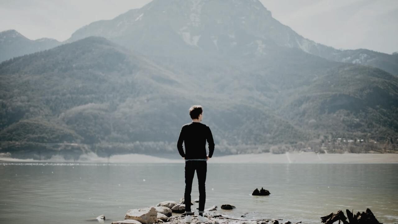 Image of a man looking in the distance across a lake